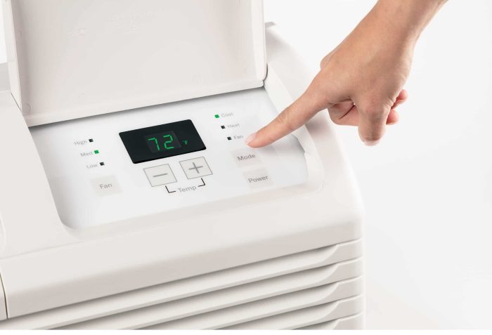 A hand adjusting settings on air conditioning unit from Hotpoint