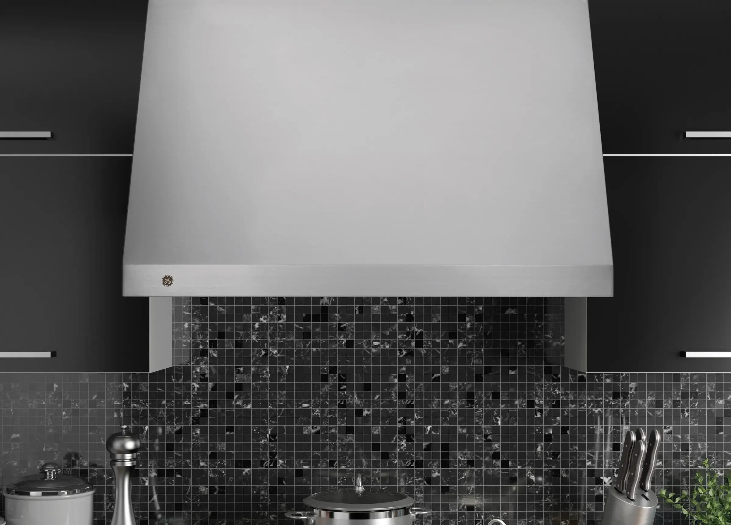 Modern kitchen with a stainless steel stove and range hood above a black mosaic tile backsplash; pots on the stove and a knife block nearby.