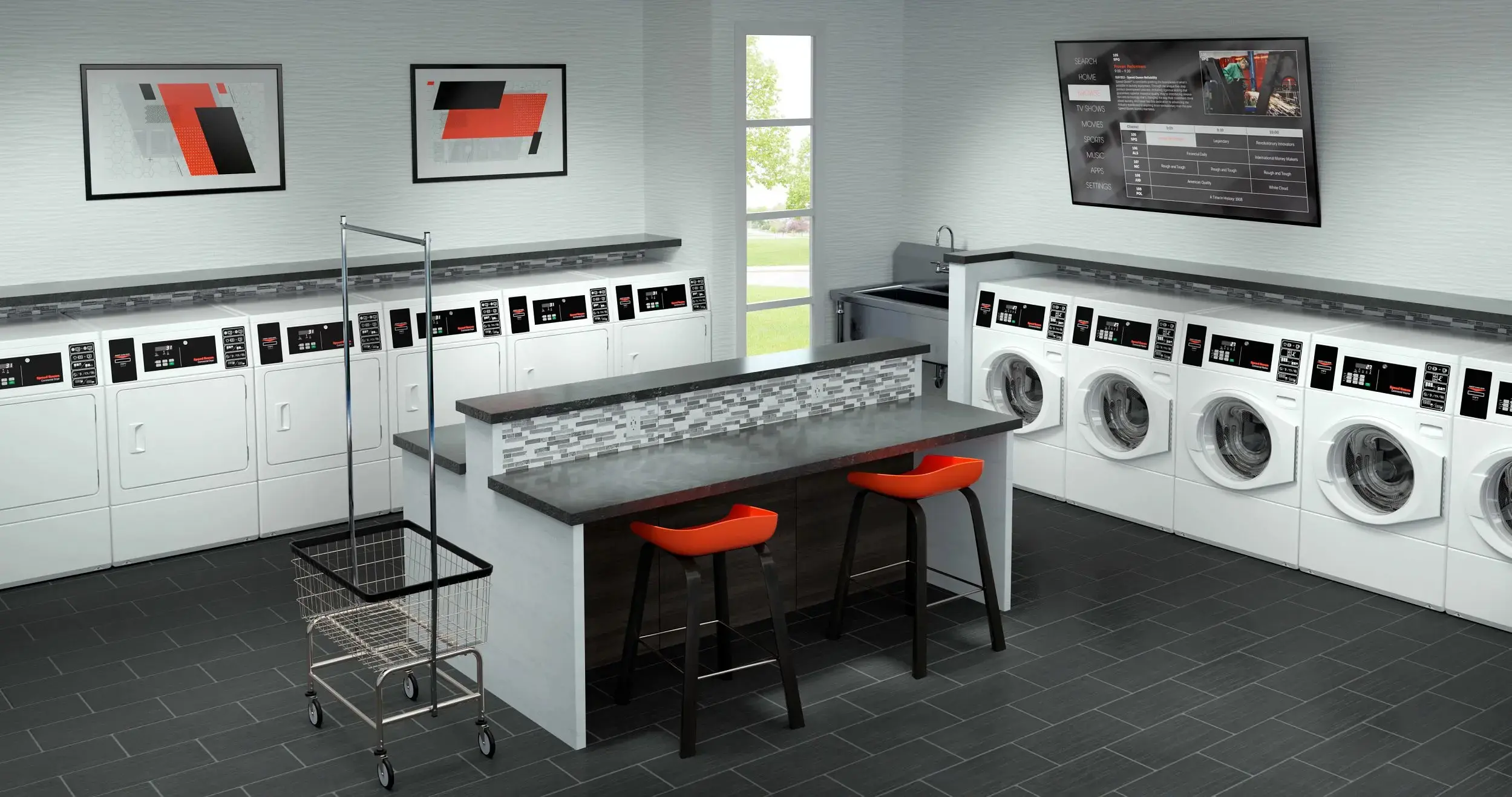 Laundromat interior with row of front-loading washing machines along the walls and a central counter with orange stools.