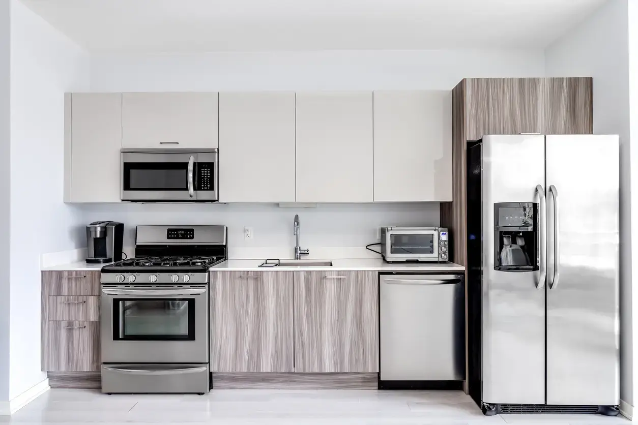 Modern kitchen featuring stainless steel refrigerator, stove, microwave, dishwasher, and coffee maker.