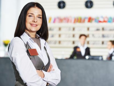 Happy female manager worker standing at hotel